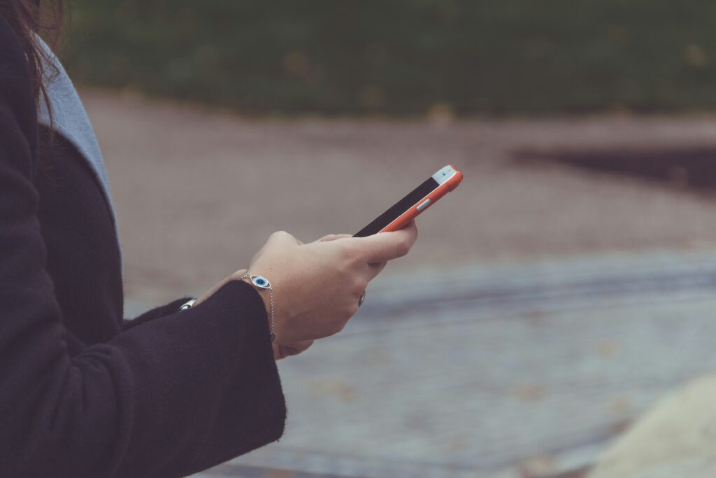 Manager donna con smartphone in ambiente professionale — stakeholder e responsabilità amministrativa da reato