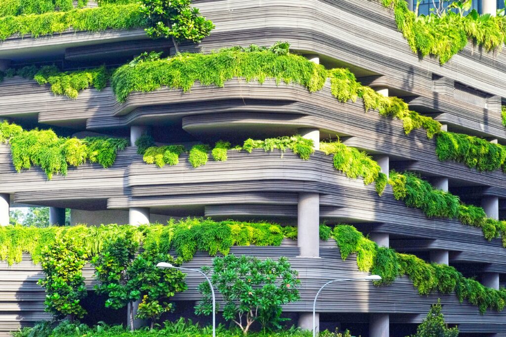 Facciata di un edificio moderno con giardini verticali e architettura biofila, metafora visiva di infrastrutture sostenibili e rating ESG aziendali.