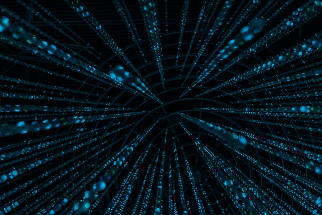 Rete di luci blu convergenti in un tunnel digitale, come nodi di sorveglianza che si concentrano verso un punto di osservazione centrale, su sfondo scuro.